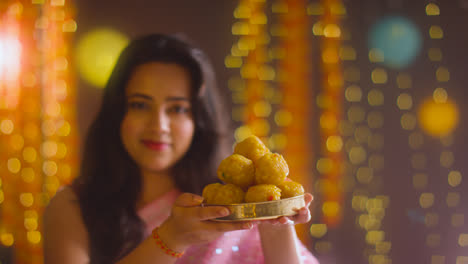 Portrait-Of-Woman-Celebrating-Festival-Of-Diwali-Holding-Dish-Of-Ladoo
